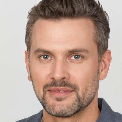 Joyful white adult male with short  brown hair and brown eyes