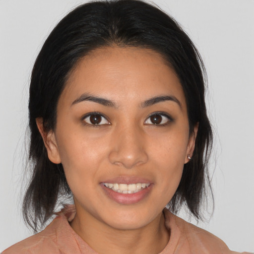 Joyful latino young-adult female with medium  brown hair and brown eyes