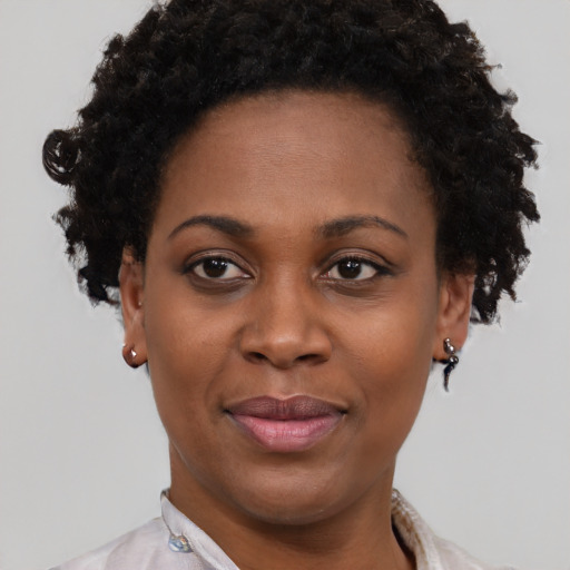 Joyful black young-adult female with short  brown hair and brown eyes