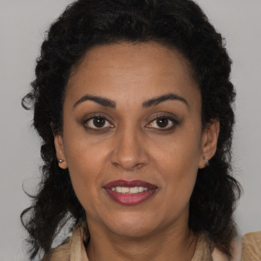Joyful latino adult female with long  brown hair and brown eyes