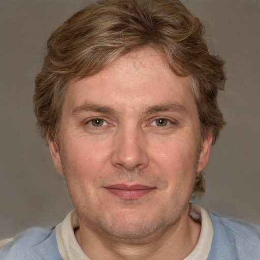 Joyful white adult male with short  brown hair and blue eyes