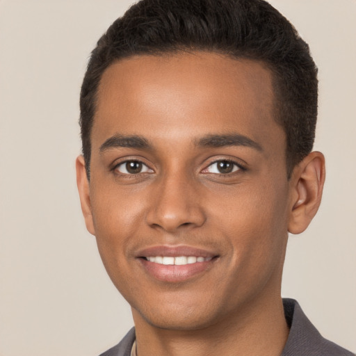 Joyful black young-adult male with short  brown hair and brown eyes