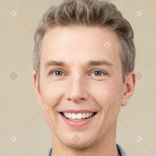 Joyful white young-adult male with short  brown hair and grey eyes