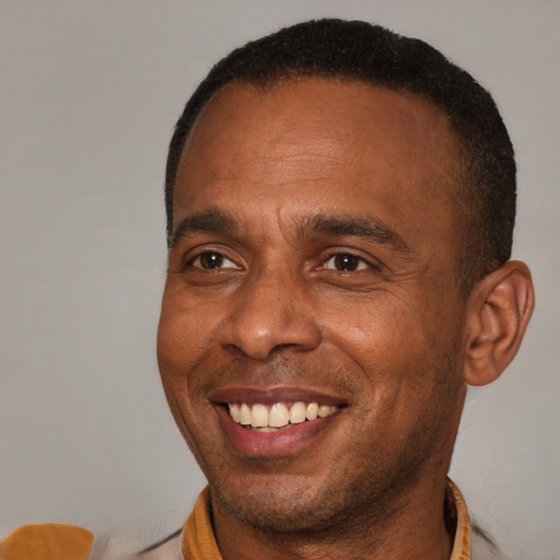 Joyful black adult male with short  brown hair and brown eyes