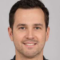 Joyful white adult male with short  brown hair and brown eyes