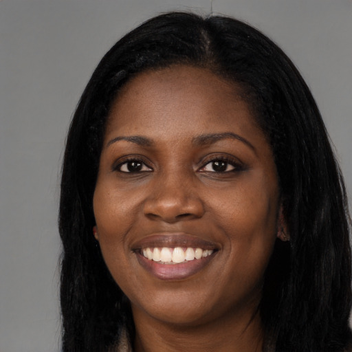Joyful black young-adult female with long  black hair and brown eyes