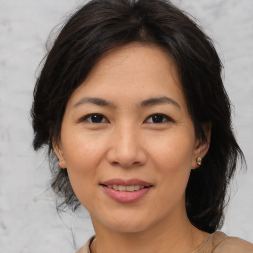 Joyful asian adult female with medium  brown hair and brown eyes