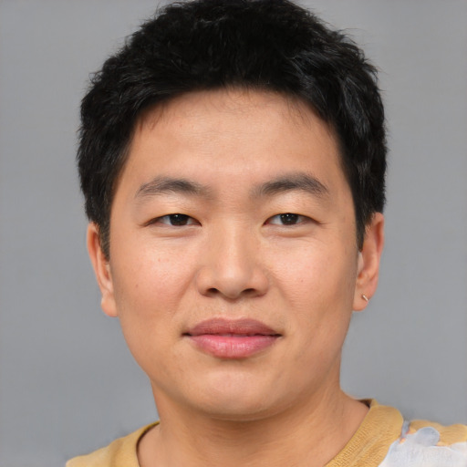 Joyful asian young-adult male with short  brown hair and brown eyes