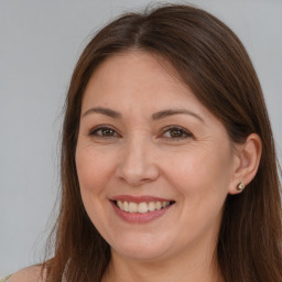 Joyful white adult female with long  brown hair and brown eyes