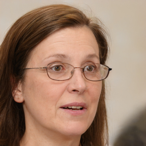 Joyful white adult female with long  brown hair and blue eyes