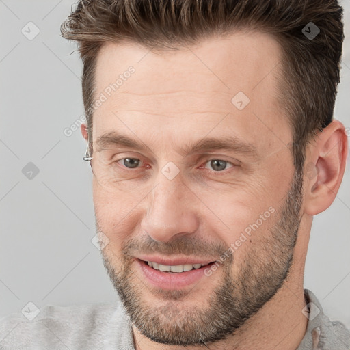 Joyful white adult male with short  brown hair and grey eyes