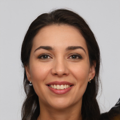 Joyful white young-adult female with long  brown hair and brown eyes