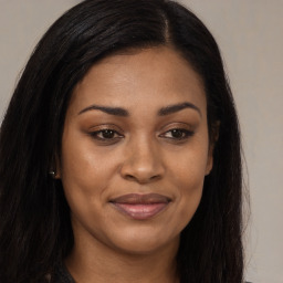 Joyful black young-adult female with long  brown hair and brown eyes