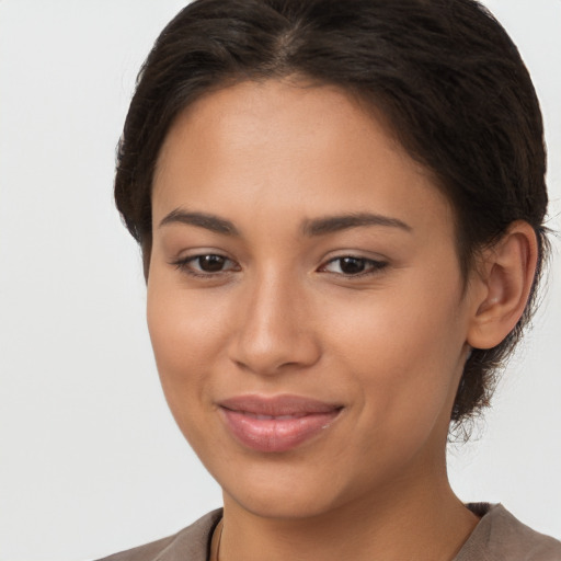 Joyful latino young-adult female with long  brown hair and brown eyes