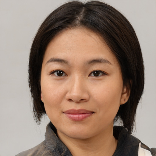 Joyful asian young-adult female with medium  brown hair and brown eyes