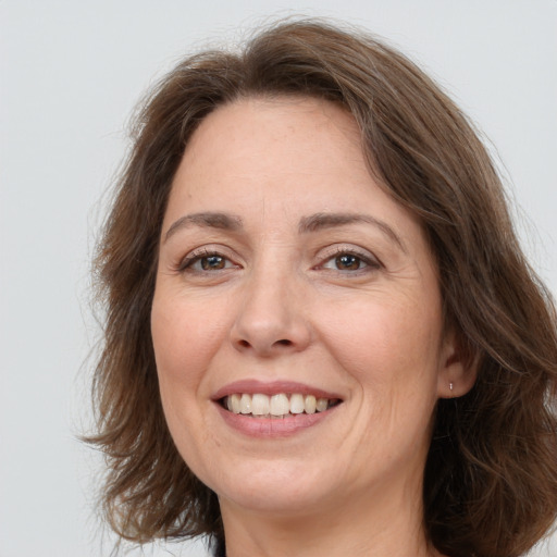 Joyful white adult female with long  brown hair and brown eyes