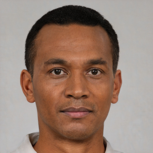 Joyful black young-adult male with short  black hair and brown eyes