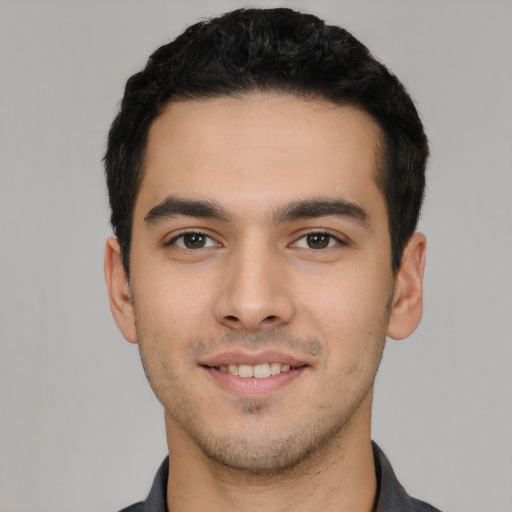 Joyful white young-adult male with short  black hair and brown eyes