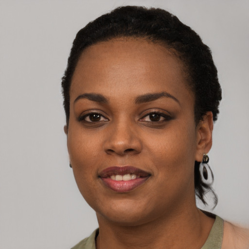 Joyful black young-adult female with short  black hair and brown eyes