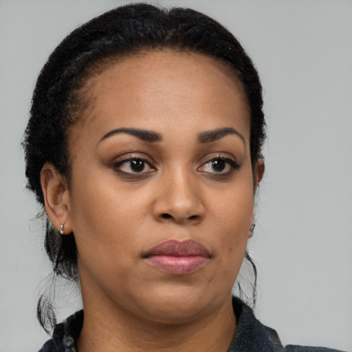 Joyful black adult female with medium  black hair and brown eyes