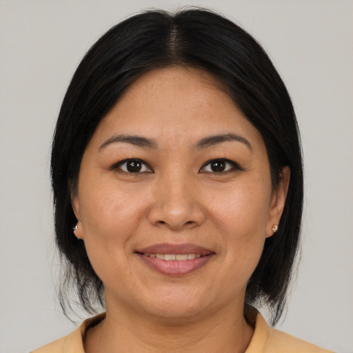 Joyful asian adult female with medium  brown hair and brown eyes