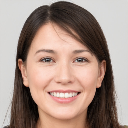 Joyful white young-adult female with long  brown hair and brown eyes