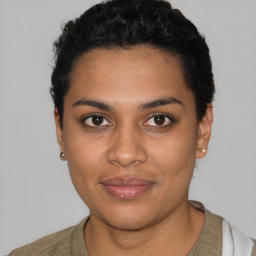 Joyful black young-adult female with short  black hair and brown eyes