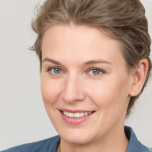 Joyful white adult female with medium  brown hair and grey eyes