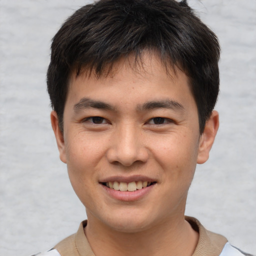 Joyful asian young-adult male with short  brown hair and brown eyes