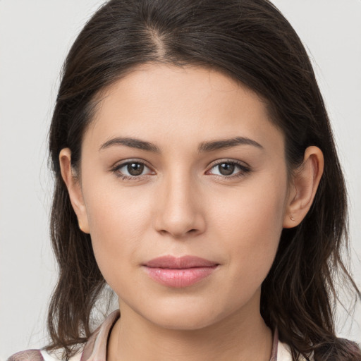 Joyful white young-adult female with long  brown hair and brown eyes