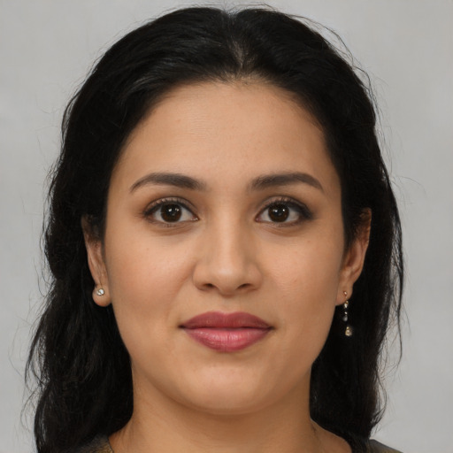 Joyful latino young-adult female with long  brown hair and brown eyes