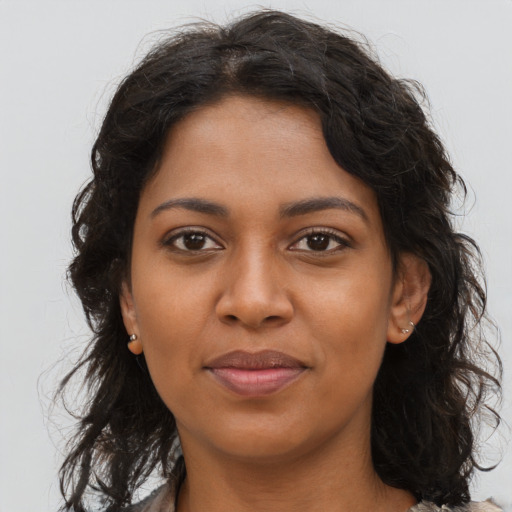 Joyful black young-adult female with long  brown hair and brown eyes