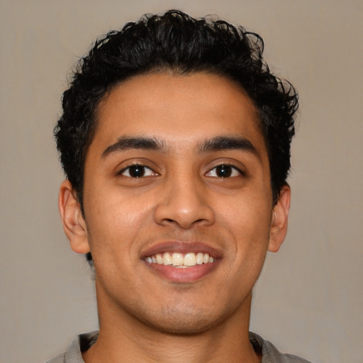 Joyful latino young-adult male with short  brown hair and brown eyes