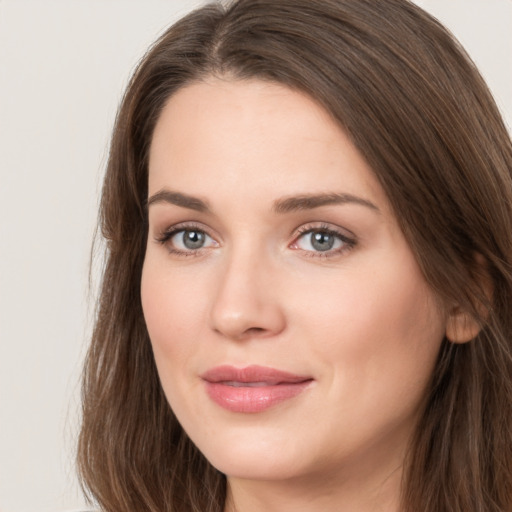 Joyful white young-adult female with long  brown hair and grey eyes