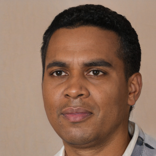 Joyful black young-adult male with short  black hair and brown eyes