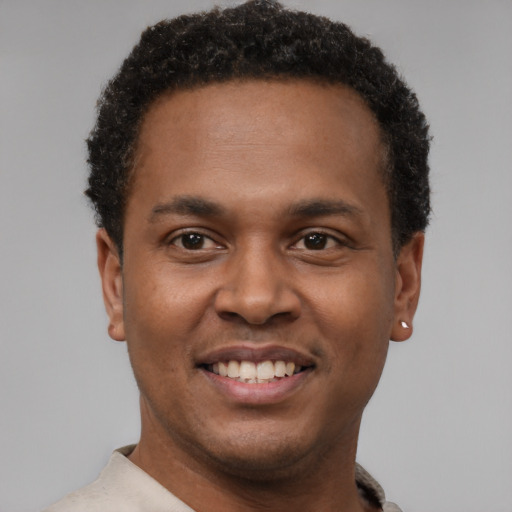 Joyful latino young-adult male with short  brown hair and brown eyes