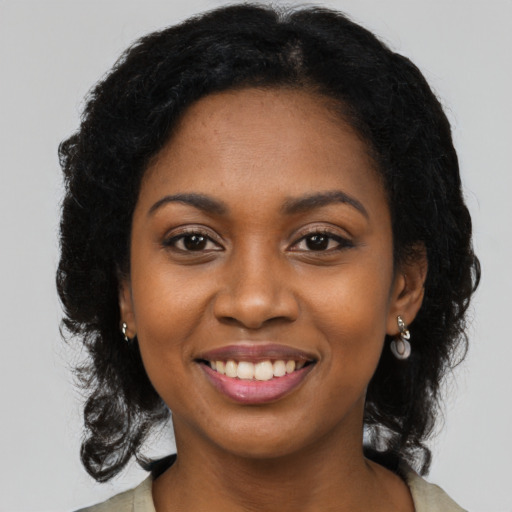 Joyful black young-adult female with long  black hair and brown eyes