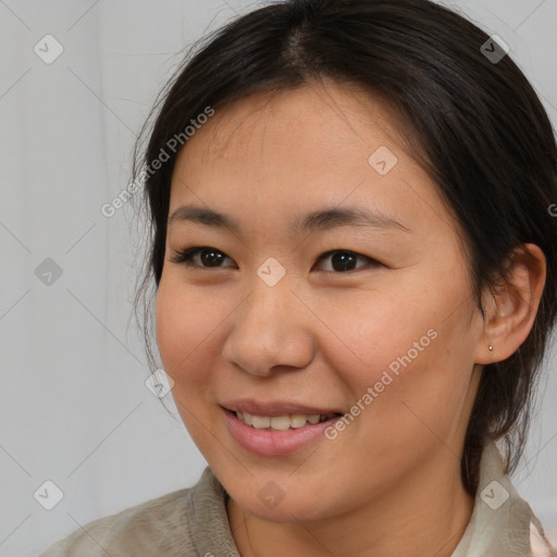 Joyful asian young-adult female with medium  brown hair and brown eyes