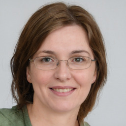 Joyful white young-adult female with medium  brown hair and green eyes