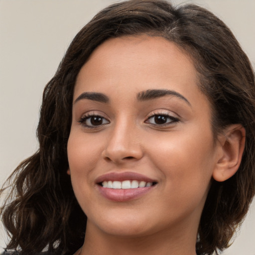 Joyful white young-adult female with long  brown hair and brown eyes