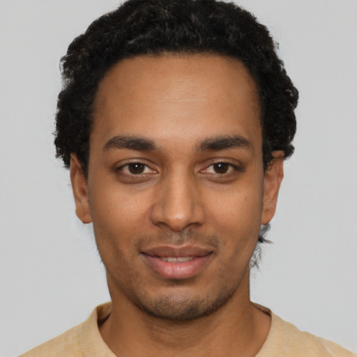 Joyful black young-adult male with short  black hair and brown eyes