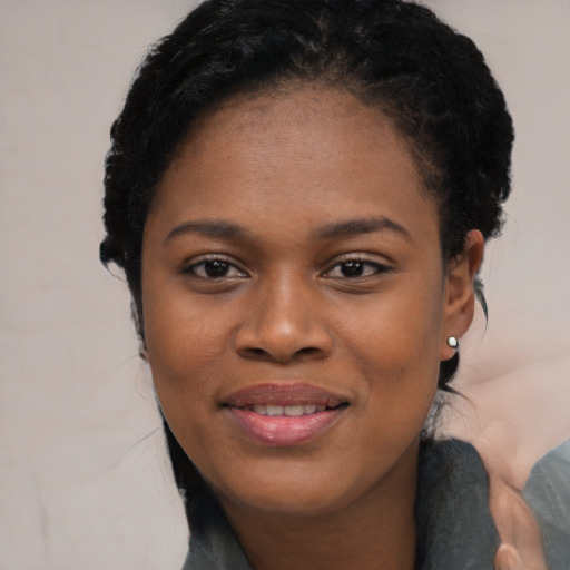 Joyful black young-adult female with short  black hair and brown eyes