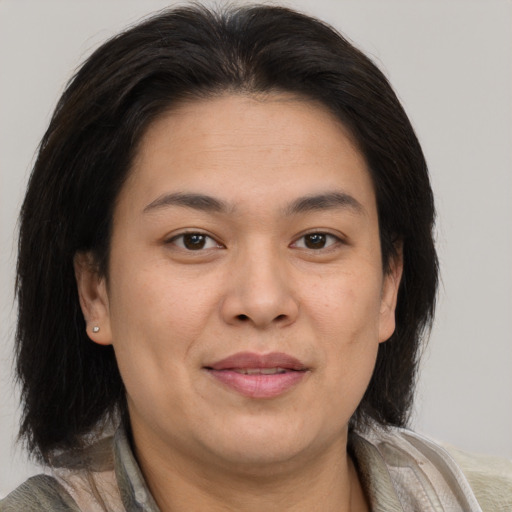 Joyful asian adult female with medium  brown hair and brown eyes