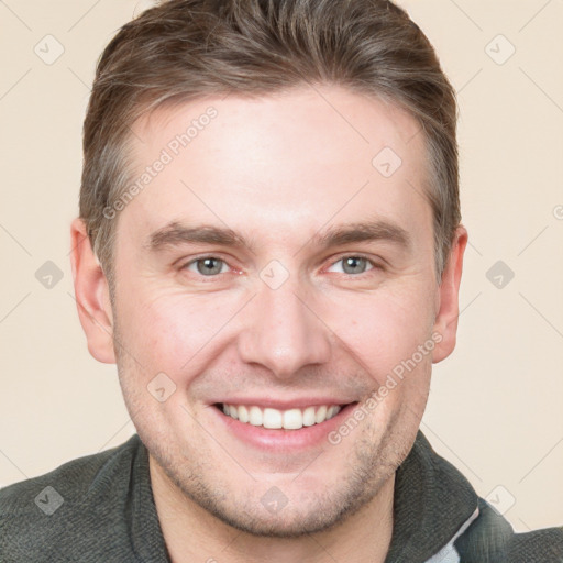 Joyful white young-adult male with short  brown hair and grey eyes