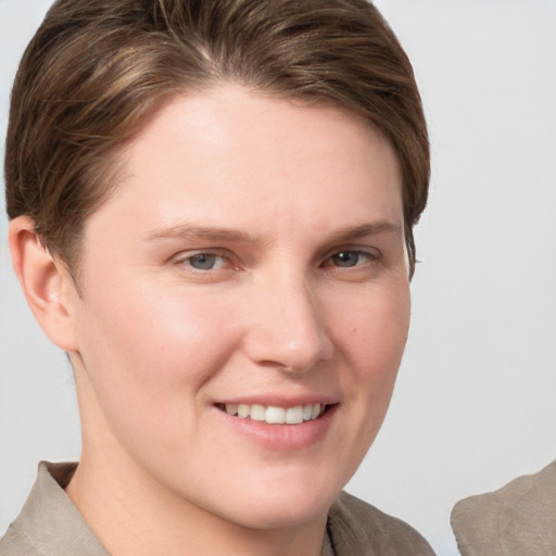 Joyful white young-adult female with short  brown hair and grey eyes