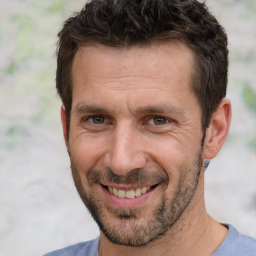 Joyful white adult male with short  brown hair and brown eyes