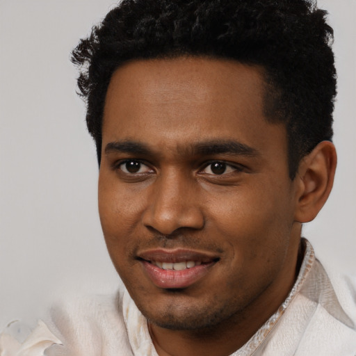 Joyful black young-adult male with short  black hair and brown eyes
