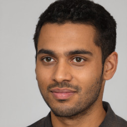 Joyful black young-adult male with short  black hair and brown eyes