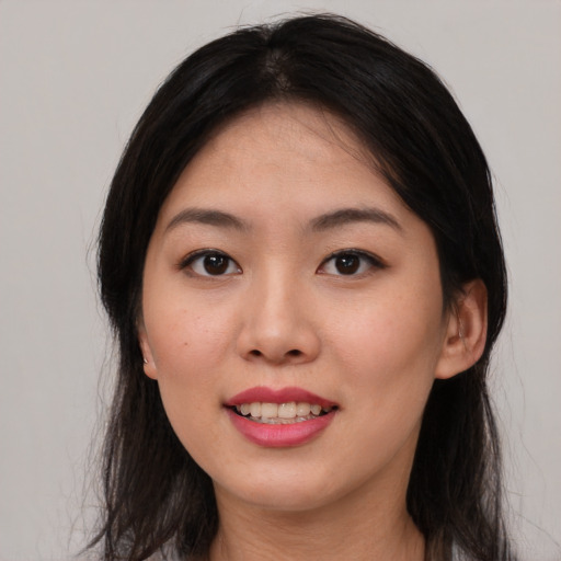 Joyful asian young-adult female with long  brown hair and brown eyes