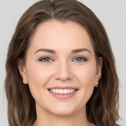 Joyful white young-adult female with long  brown hair and grey eyes